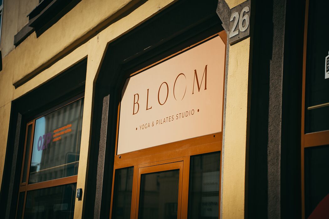 Cedule Bloom Yoga & Pilates Studio nad vchodem do budovy na Českobratrské 26
